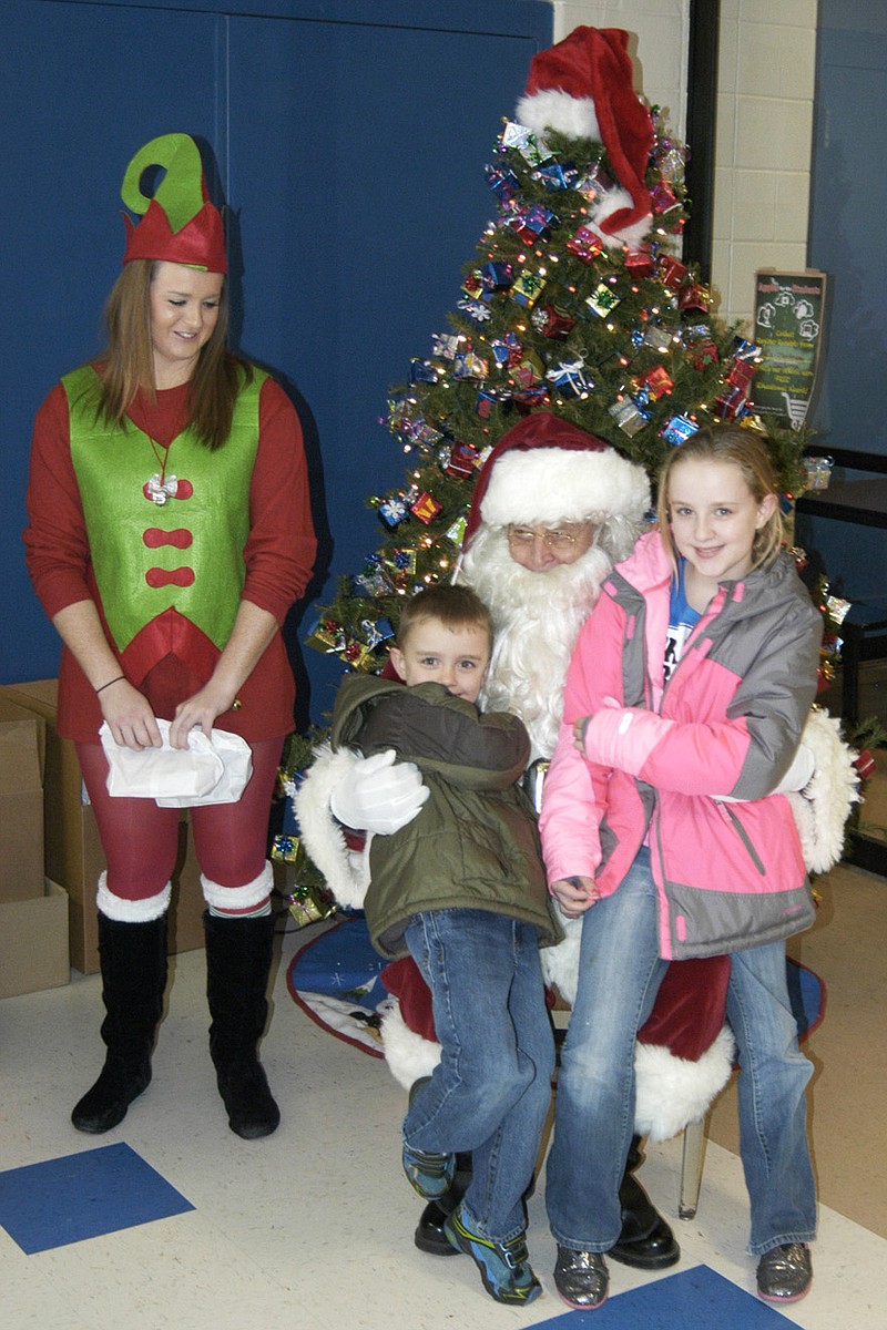 Democrat photo / David A. Wilson
Kyle and Kaitlyn sit on Santa's lap Saturday, at the Jamestown school, as an elf stands by.