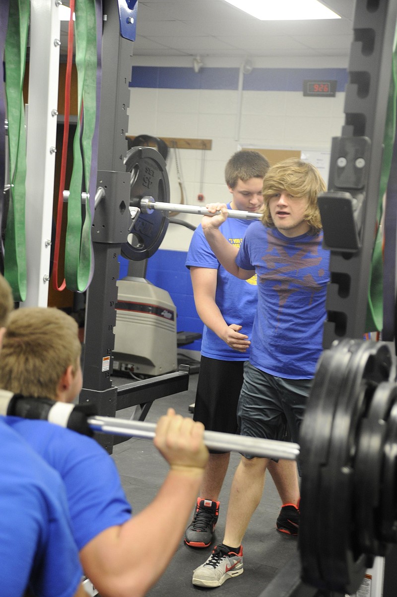 Johnathan Thomas lifts with his legs while Chris Wolfe spots his posture in the newly-improved weight room at Cole County R-1 High School. Democrat staff/Michelle Brooks