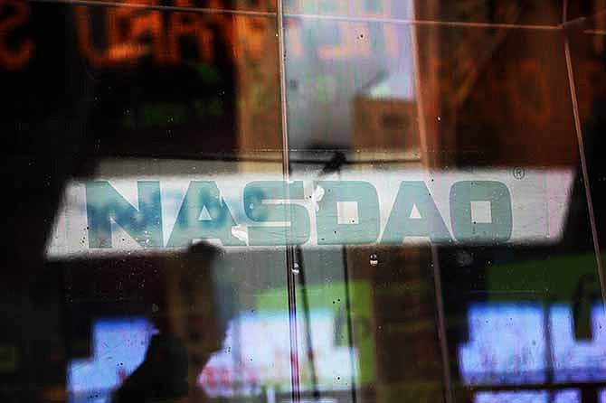 In this Thursday, Aug. 22, 2013, file photo, electronic billboards are reflected in the windows of Nasdaq in New York.