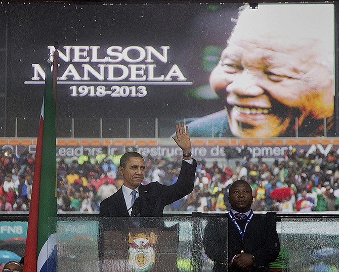 President Barack Obama waves as he arrives to speak to crowds attending the memorial service Tuesday for former South African president Nelson Mandela at the FNB Stadium in Soweto near Johannesburg. 