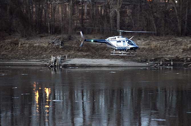 
The pilot flies the Missouri Highway Patrol helicopter low over the Missouri River just east of the Jefferson City bridges in search of a person who may have jumped from the pedestrian bridge. 