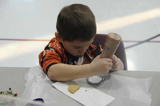 Five-year-old Talon Barb concentrates on gluing his hand-drawn Nativity picture onto a frozen juice lid to create an ornament. The craft project at the Eugene Christian Church after-school program will be donated to the Eldon Community Food Pantry.