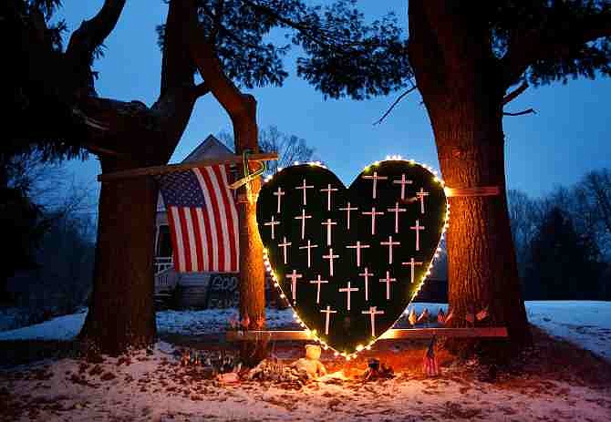 A makeshift memorial with crosses for the victims of the Sandy Hook massacre stands outside a home in Newtown, Conn., Saturday, Dec. 14, 2013, the one-year anniversary of the shootings.