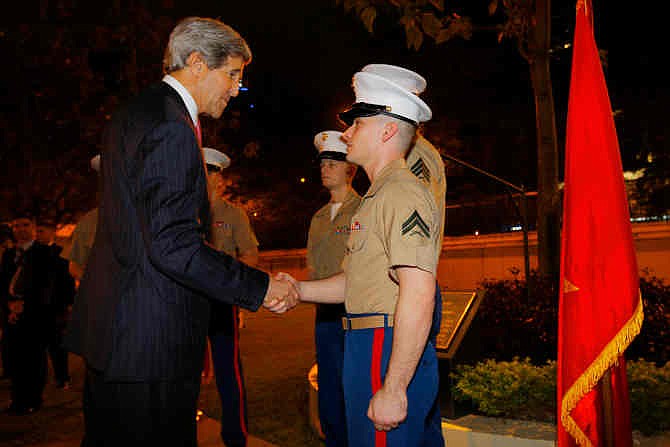 U.S. Secretary of State John Kerry, left, greets a new five-member U.S. Marine detachment at the U.S. Consulate in Ho Chi Minh City, Vietnam Saturday, Dec. 14, 2013. Forty-four years after first setting foot in the country as a young naval officer, Kerry returned once more to Vietnam on Saturday, this time as America's top diplomat offering security assurances and seeking to promote democratic and economic reform.