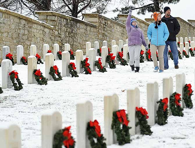 Ryan Klatt walks along with his daughter Abbie Klatt, center, and her Trinity Lutheran School classmate Grace Bailey, left, after helping lay wreaths at the headstones of veterans buried at Jefferson City National Cemetery during Saturday's annual Wreaths for Heroes Ceremony. 