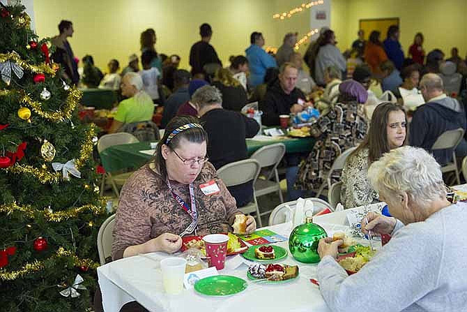 Dulle and Hamilton towers residents enjoy a catered Christmas dinner while others wait in line during a Christmas party held in the cafeteria Saturday afternoon.