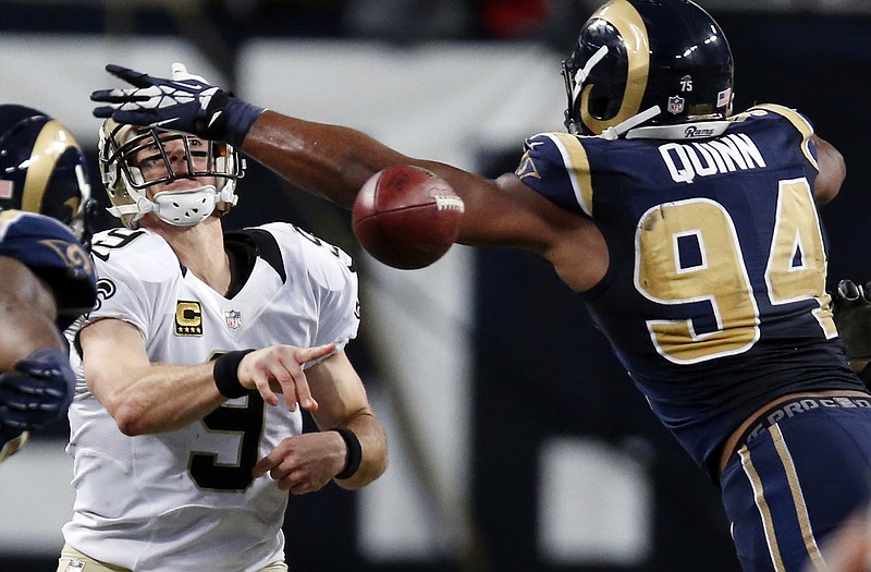 Saints quarterback Drew Brees (9) gets rid of a pass while under pressure from Rams defensive end Robert Quinn during the fourth quarter of Sunday's game in St. Louis.