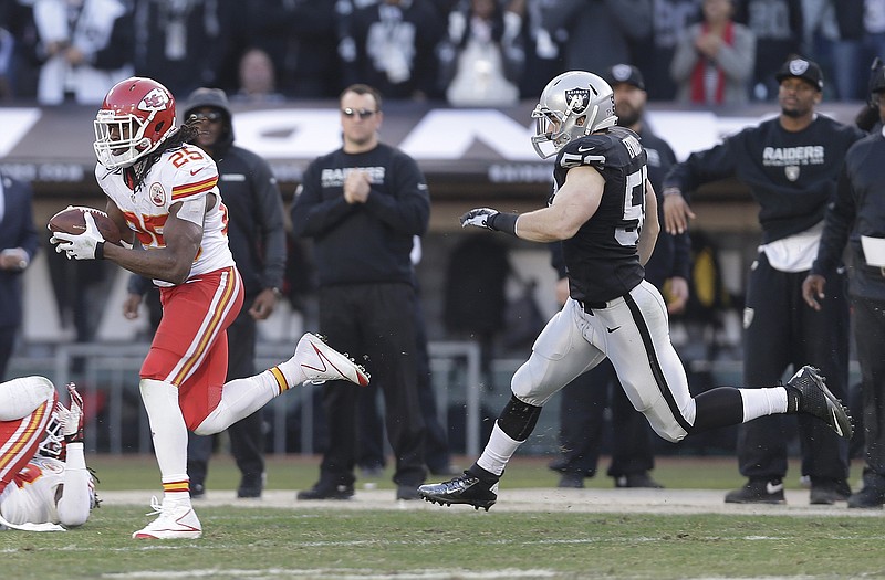 Chiefs running back Jamaal Charles (25) runs away from Raiders linebacker Miles Burris while scoring on a 71-yard touchdown pass from quarterback Alex Smith during the third quarter of Sunday's game in Oakland, Calif.