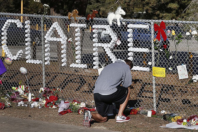 Parker Semin, a 2011 Arapahoe High School graduate, prays at a makeshift memorial bearing the name of wounded student Claire Davis, who was shot by a classmate during school last week.
