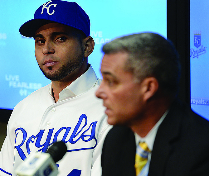 Omar Infante listens as Royals general manager Dayton Moore speaks during a news conference Tuesday at Kauffman Stadium.