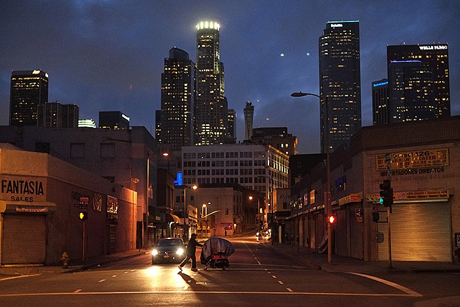 A homeless man pushes a shopping cart full of his belongings across an intersection in the Skid Row area of Los Angeles. The growing gap between the richest Americans and everyone else isn't bad just for individuals, it's hurting the U.S. economy says a majority of more than three dozen economists surveyed in December 2013 by The Associated Press.