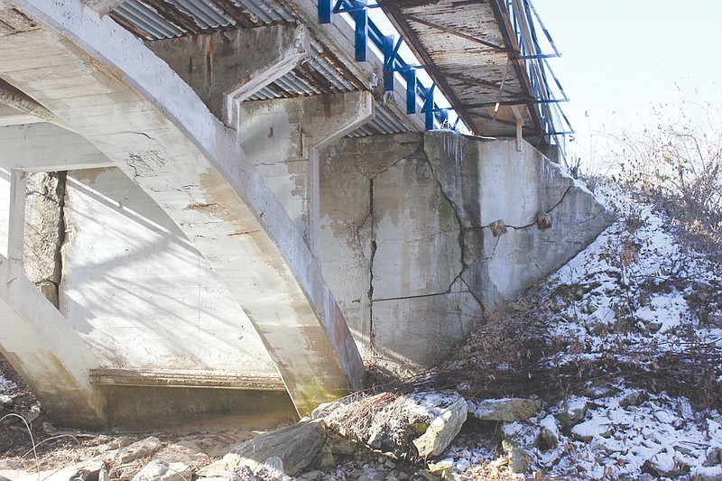 The Seventh Street bridge, as seen from the Stinson Creek trail under its span, reveals cracks in the retaining wall, holes in the pedestrian walkway and other structural problems. City officials plan to bid a project in February to completely replace the bridge.