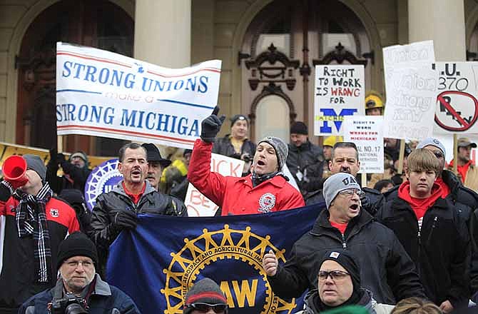 In this Dec. 11, 2012 file photo some of the thousands that gathered for a rally protest against the passage of right-to-work legislation outside the State Capitol in Lansing, Mich. Buoyed by recent successes in the Midwest, supporters of right-to-work laws are targeting at least three states in 2014 with measures that could curb union powers by ending their ability to collect mandatory bargaining fees. 
