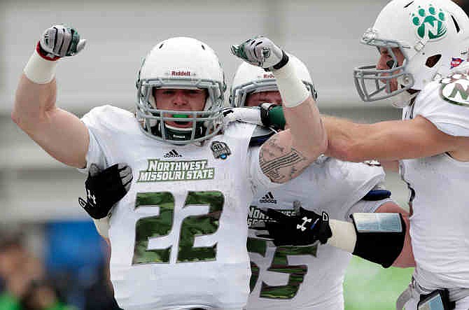 NW Missouri State running back Billy Creason (22) reacts with teammate Cole Forney (55) and others after scoring a touchdown against Lenoir Rhyne during the first half of the NCAA Division II championship college football game in Florence, Ala., Saturday, Dec. 21, 2013.