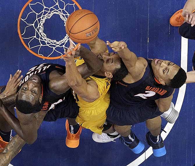 Missouri's Johnathan Williams III, center, goes up for a rebound with Illinois' Nnanna Egwu, left, and Joseph Bertrand, right, during the second half of an NCAA college basketball game on Saturday, Dec. 21, 2013, in St. Louis. Illinois won 65-64. 