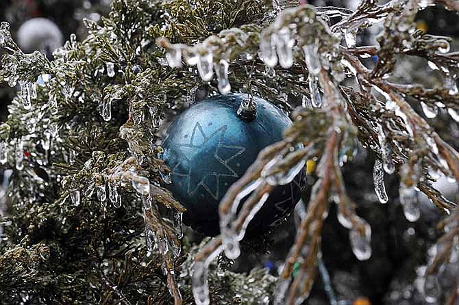 An ornament is held in its place by the ice-encapsulated branches of the Jefferson City mayor's Christmas tree on Bolivar Street on Saturday, Dec. 21, 2013 following the previous night's freezing rain.