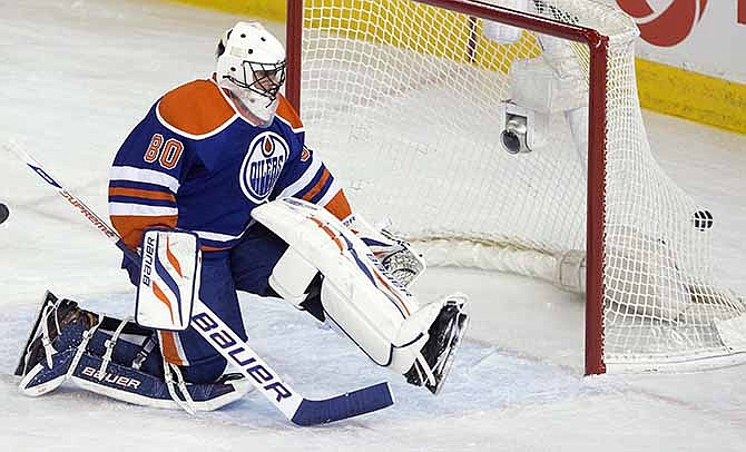 Edmonton Oilers goalie Ilya Bryzgalov (80) is scored on by the St. Louis Blues during the first period of an NHL hockey game in Edmonton, Alberta, on Saturday, Dec. 21, 2013. 