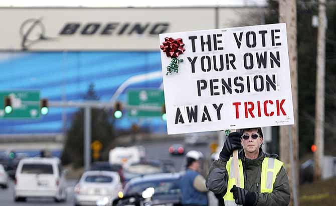 Boeing machinists union member Kevin Flynn walks near a union hall in Everett, Wash., on Dec. 18, 2013, in support of his leaders' rejection of Boeing's last contract offer as he waits for a small group of protesters who instead favor a vote. National union leaders are scheduling another chance to vote on a contract that would keep production of the new 777X in Washington.