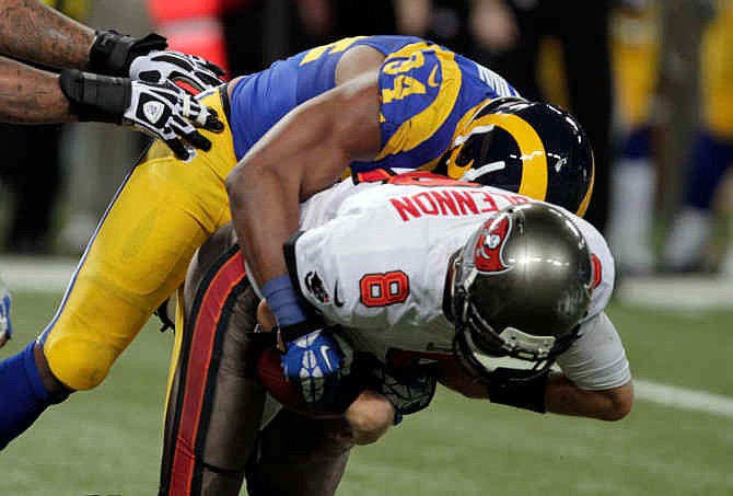 St. Louis Rams defensive end Robert Quinn, top, sacks Tampa Bay Buccaneers quarterback Mike Glennon for a 4-yard loss during the fourth quarter of an NFL football game on Sunday, Dec. 22, 2013, in St. Louis. The Rams won 23-13.
