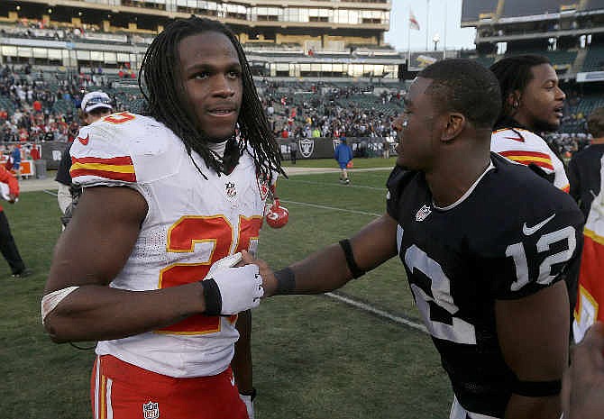 Kansas City Chiefs running back Jamaal Charles, left, shakes hands with Oakland Raiders wide receiver Jacoby Ford (12) after an NFL football game in Oakland, Calif., Sunday, Dec. 15, 2013.