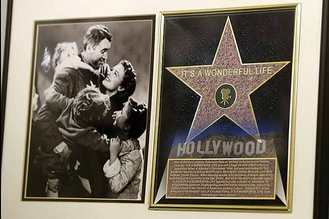 In this photo made on Friday, Dec. 20, 2013, a framed plaque with a photograph of a scene from the 1946 film "It's A Wonderful Life" starring Jimmy Stewart, left, and a Hollywood star are on display at the Jimmy Stewart Museum in Indiana, Pa. The museum dedicated to the life of the star of many films including the holiday favorite "It's A Wonderful Life" is located in the off-the-beaten track town where Stewart grew up. The museum still attracts visitors from all over the country. It's full of displays not just about Hollywood, but about Stewart's service as a bomber pilot in World War II, his well-to-do ancestors, and his family life.