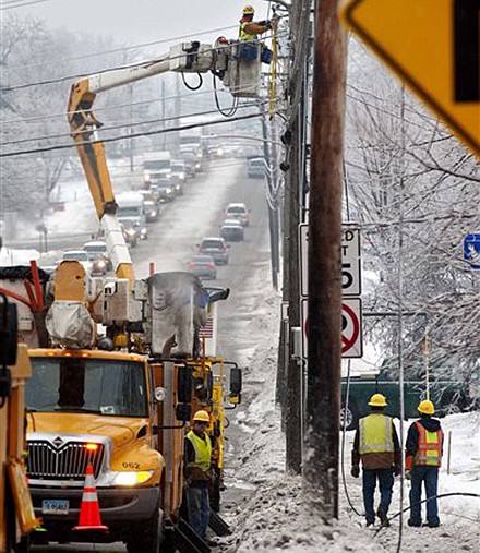 Utility crews respond Monday to a downed power line at an intersection in South Burlington, Vt.. From Michigan to Maine, hundreds of thousands remain without power days after a massive ice storm blacked out homes and businesses in the Great Lakes and Northeast.