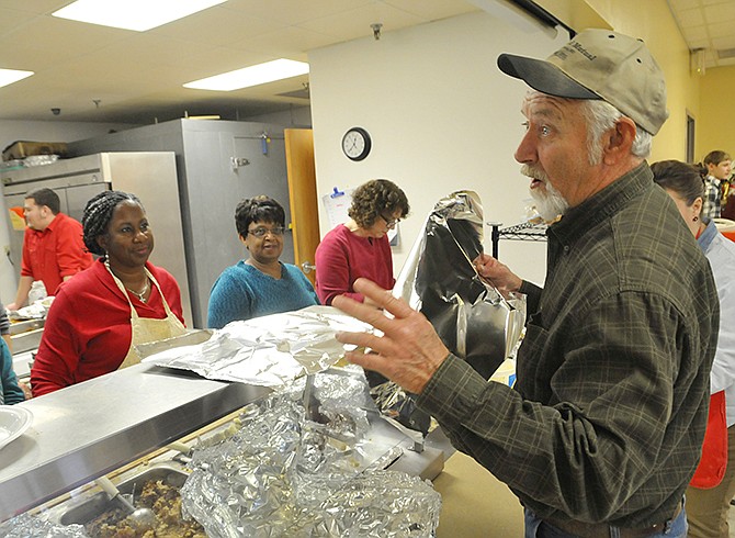 Johnny Roush talks to the volunteers behind the food counter as he and several other volunteers from California helped to serve lunch at the Salvation Army on Christmas Day. Several of the people serving food are from House of Prayer and House of Refuge churches in Jefferson City and one from Westphalia. They delivered the food to people seated at the tables and packaged up the leftovers so the patrons could take the food with them.