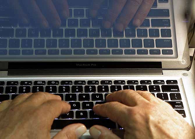  In this photo illustration, hands type on a computer keyboard in Los Angeles. Companies including Google and the Huffington Post are trying everything from deploying moderators to forcing people to use their real names in order to restore civil discourse on online comment threads.