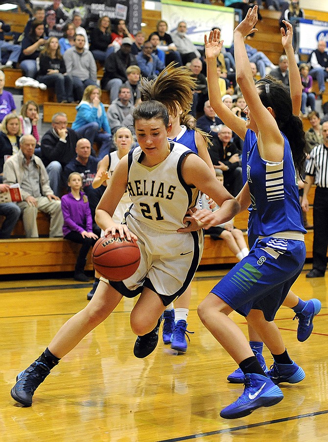 Helias' Mai Nienhueser drives past Blue Springs South's Naia Tauai during Friday action at the State Farm Holiday Hoops Invitational at Rackers Fieldhouse.