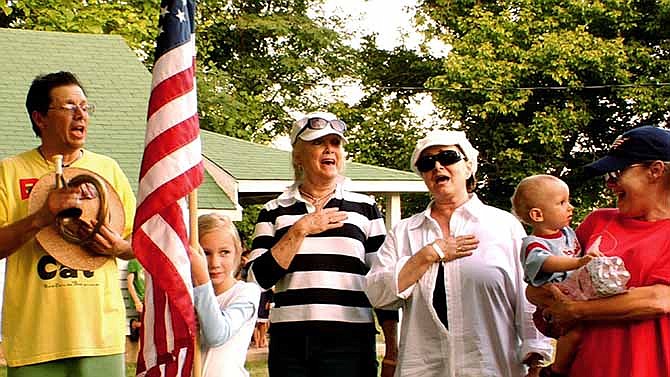 In this July 4, 2008 image from video provided by David Wilson, Bill Lennon, left, and his sisters Diane, center left, Peggy, center right, and Janet, right, who were a household name to millions during their heyday on the Lawrence Welk show, sing the The Star-Spangled Banner with unidentified family members on the family ranch near Branson, Mo. The Lennon's are one of four families living in the Branson area that documentary filmmakers David Wilson and A.J. Schnack followed over five years to produce "We Always Lie to Strangers," a middle America, flag-waving, family-friendly celebration of musical variety shows and early-bird dinner specials.