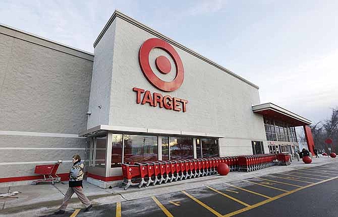 In this Dec. 19, 2013 file photo, a passer-by walks near an entrance to a Target retail store in Watertown, Mass. 