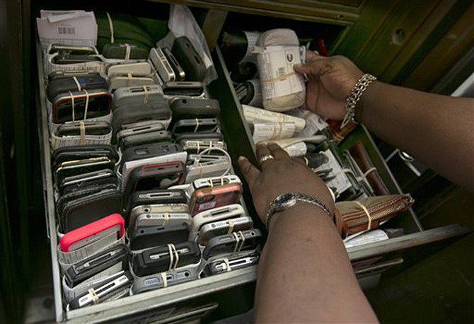 Manager Melissa Gissentanner looks through the current month's drawers of lost mobile phones and wallets in the safe of the MTA Metro-North Lost and Found department, at New York's Grand Central Terminal. 