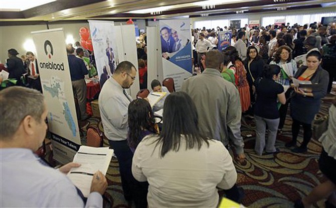 Job seekers check out companies at a job fair in Miami Lakes, Fla. in August. More than 1 million Americans are bracing for a harrowing, post-Christmas jolt as federal unemployment benefits come to a sudden halt this weekend. 