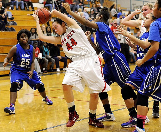 Jefferson City's Sidney McMillan grabs the ball as Southeast's Indica Hawkins (12) and Treasure Gordon (25) look on Friday during the State Farm Holiday Hoops Invitational at Rackers Fieldhouse.