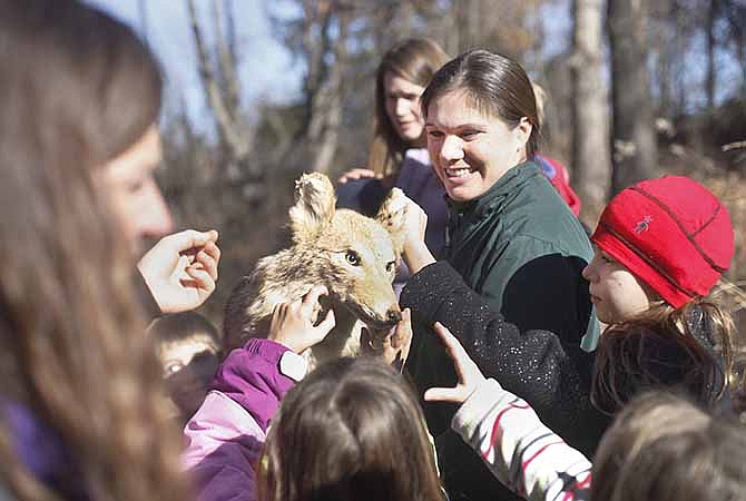 
Kids feel a stuffed coyote held up by Becky Matney, a staff member at Runge Nature Center, that was hidden in the tall grass to point out the animal's ability to camouflage itself on the Camo Trail Walk on Saturday morning. The walk was a part of the Holiday Happenings: Designed by Nature event.