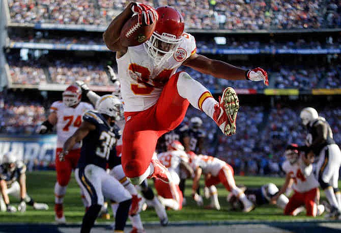 Kansas City Chiefs running back Knile Davis, center, jumps in the end zone as he scores a touchdown against the San Diego Chargers during the first half of an NFL football game, Sunday, Dec. 29, 2013, in San Diego. 