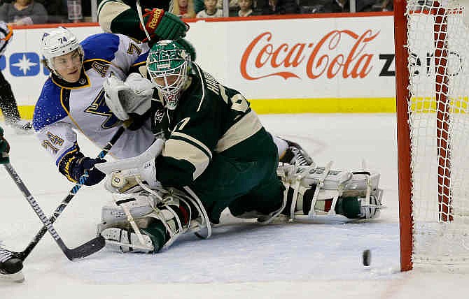 St. Louis Blues right wing T.J. Oshie (74) scores on Minnesota Wild goalie Josh Harding, right, during the second period of an NHL hockey game in St. Paul, Minn., Tuesday, Dec. 31, 2013.