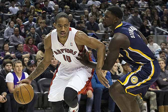 Toronto Raptors' DeMar DeRozan, left, drives at Indiana Pacers' Lance Stephenson during the first half of an NBA basketball game in Toronto on Wednesday, Jan. 1, 2014.
