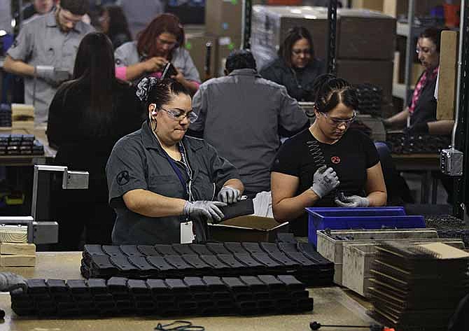 In this Feb. 28, 2013 file photo, workers assemble 30-round capacity ammunition magazines for high-velocity rifles, inside the Magpul Industries plant in Erie, Colo. Magpul, one of the country's largest producers of ammunition magazines for guns, is leaving Colorado and moving operations to Wyoming and Texas because of new state laws that include restrictions on how many cartridges a magazine can hold. 