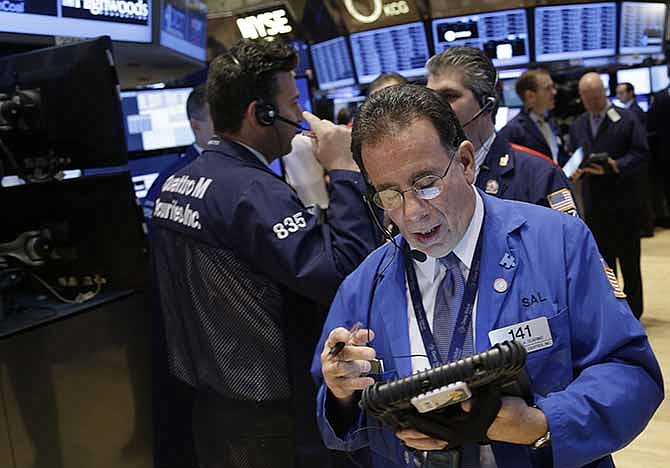 In this Tuesday, Dec. 31, 2013 file photo, traders work on the floor at the New York Stock Exchange in New York. It's a new year, so once again it's time to take "Dogs of the Dow" out for a run. This annual Wall Street strategy has investors kick off January 2014 by buying the 10 highest-yielding stocks in the Dow Jones industrial average and hold them for rest of the year. 