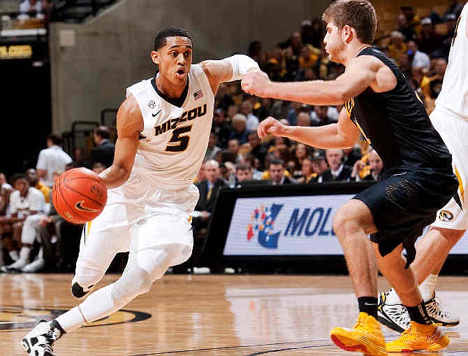 Missouri's Jordan Clarkson, left, dribbles around Long Beach State's McKay LaSalle, right, during the first half of an NCAA college basketball game Saturday, Jan. 4, 2014, in Columbia, Mo. 