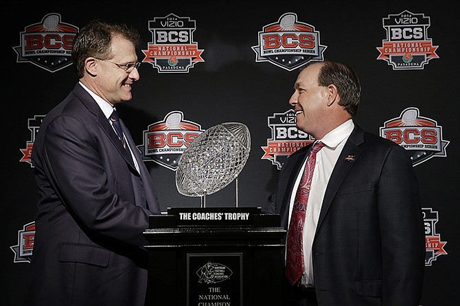 Auburn head coach Gus Malzahn (left) and Florida State head coach Jimbo Fisher shake hands in front of The Coaches' Trophy during a news conference Sunday for the BCS National Championship in Newport Beach, Calif. Florida State plays Auburn tonight.