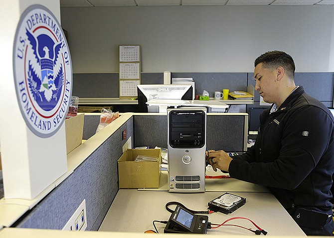 Army Staff Sgt. Oskar Zepeda removes a hard drive from a computer seized as evidence, at a Digital Forensics Lab at an Immigration and Customs Enforcement field office in Seattle, where he is serving a one-year internship. Zepeda, who served nine tours of duty in Iraq and Afghanistan, before being wounded, is part of a 17-member class of veterans deployed to ICE field offices throughout the country to use his newly acquired skills in computer forensics to help capture and prosecute child predators.