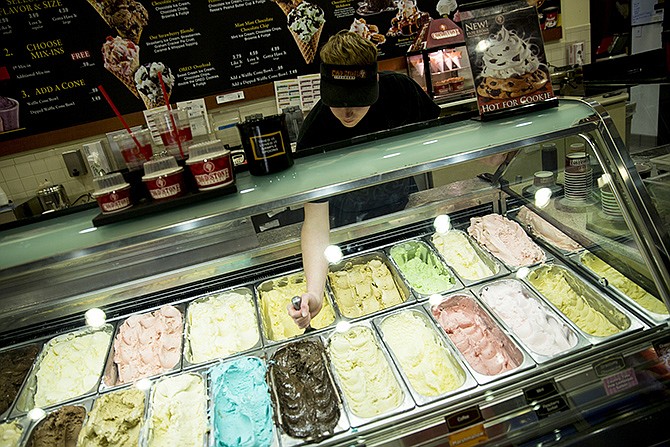 Cold Stone Creamery employee Lance Talbert stirs ice cream while waiting for customers Tuesday evening.
