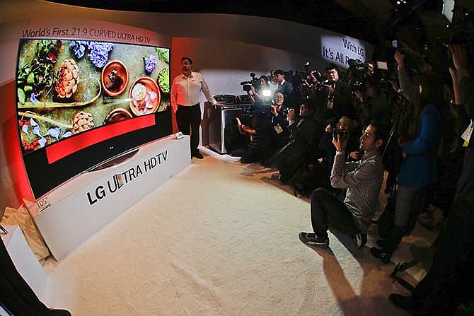 Members of the media photograph an LG 105-inch curved Ultra HDTV during the 2014 Consumer Electronics Show, Monday, Jan. 6, 2014, in Las Vegas.