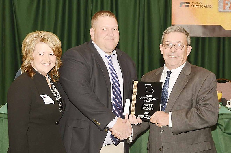 MFB President Blake Hurst presents Andy and Kacey Clay with  the Young Farmers and Ranchers Achievement Award at the Farm Bureau annual meeting held at Tan-Tar-A Dec. 7-10, 2013.