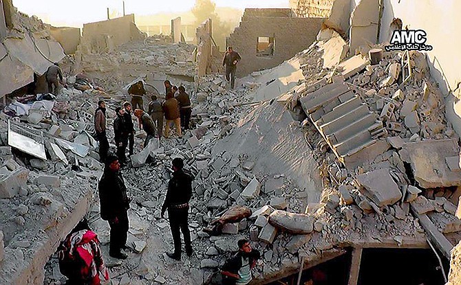 Provided by Aleppo Media Center, AMC, Syrians inspect the rubble of destroyed buildings following a Syrian government airstrike in Aleppo, Syria. 