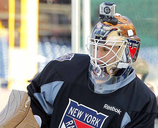 In this Sunday Jan. 1, 2012 file photo, New York Rangers' goalie Martin Biron, sporting a helmet camera, warms up during practice for the Winter Classic hockey game, in Philadelphia. For adventure athletes, it's the new essential: a video of their exploits.