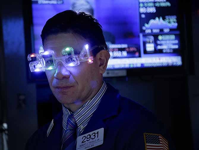 In this Tuesday, Dec. 31, 2013, file photo, a trader wears glasses celebrating the new year while working on the floor at the New York Stock Exchange in New York.
