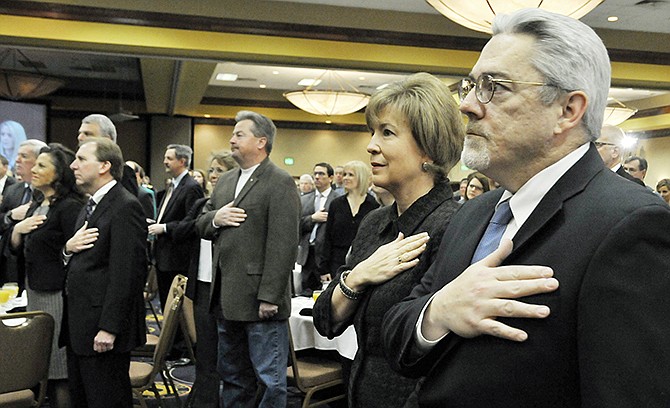 Missouri Supreme Court Judges Paul Wilson and Mary R. Russell, along with the rest in attendance, hold their hands over hearts as the Pledge of Allegiance is recited Thursday morning at the Governor's Prayer Breakfast. 